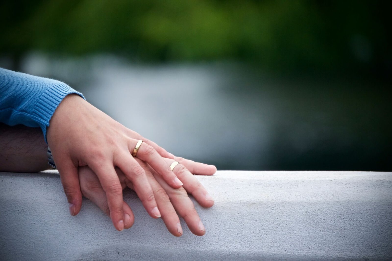 two-hands [husband and wife]-on-gray-surface